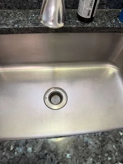 Polished and spotless stainless steel basin after a complete kitchen sink deep cleaning.